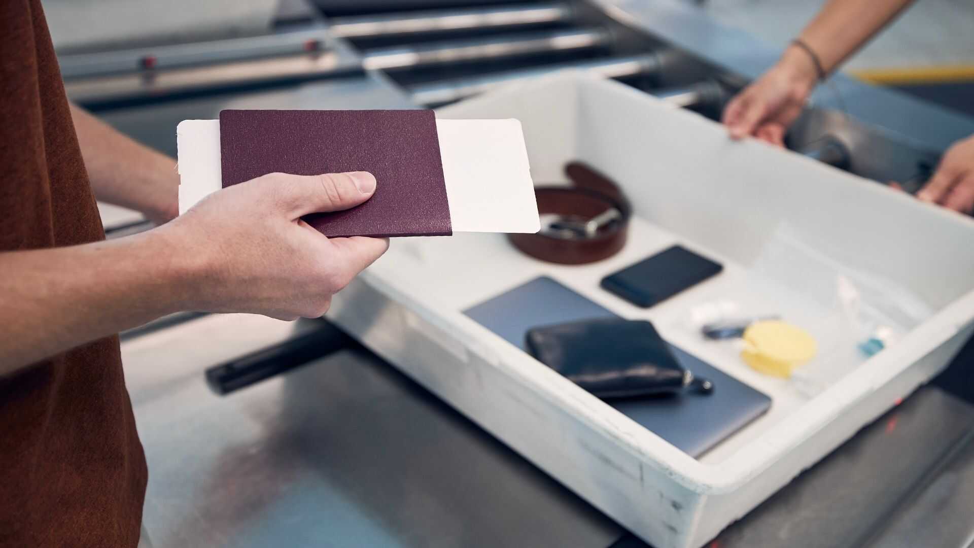 Passenger holding passport and boarding pass at a fast-track security checkpoint for a charter group flight.
